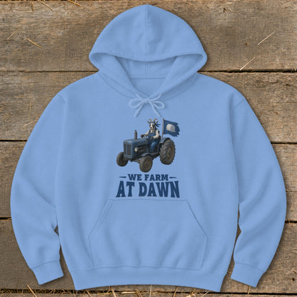 Light blue hoodie with graphic of a goat driving a tractor, text reads "We Farm At Dawn".