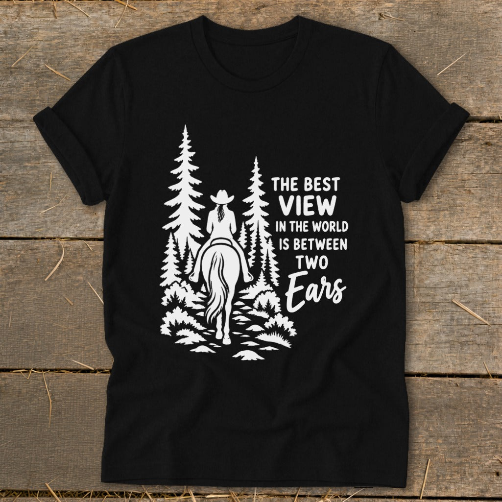 Black t-shirt featuring a white graphic of a horseback rider in the woods with the text The Best View In The World Is Between Two Ears.