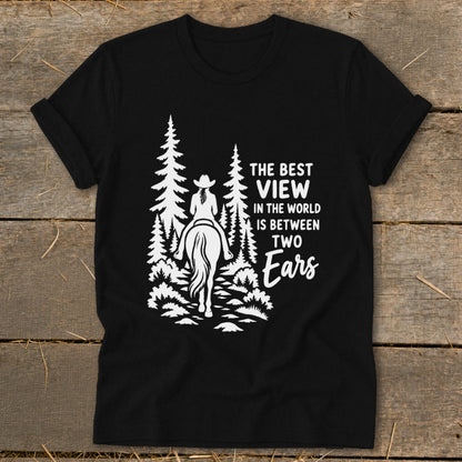 Black t-shirt featuring a white graphic of a horseback rider in the woods with the text The Best View In The World Is Between Two Ears.