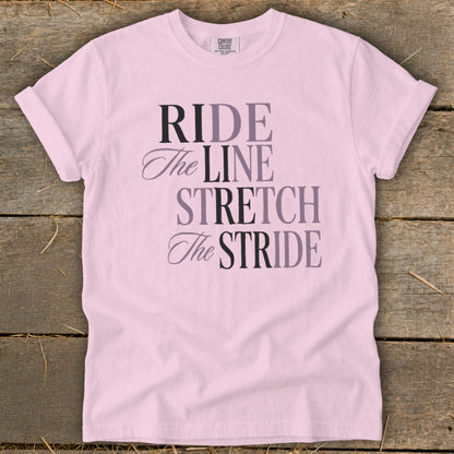 Pink t-shirt with text "RIDE The LINE STRETCH The STRIDE".