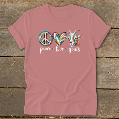Pink t-shirt with peace sign, heart, and colorful goat graphic and text reading "peace love goats".