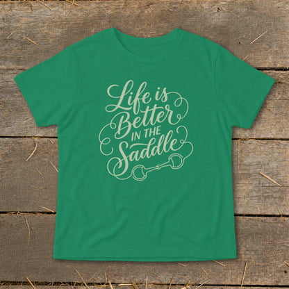Green t-shirt with "Life is Better IN THE Saddle" text and horse bit graphic.