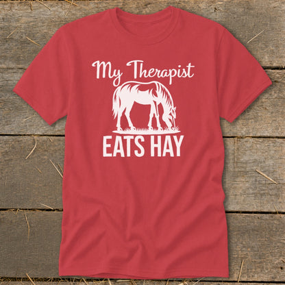 Red t-shirt with white text "My Therapist Eats Hay" and a horse graphic.