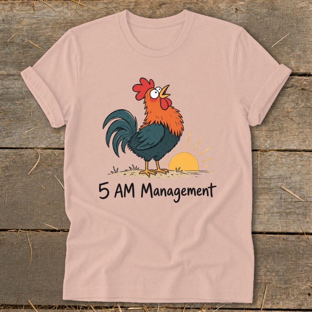 Pink t-shirt with cartoon rooster crowing at sunrise and text "5 AM Management".