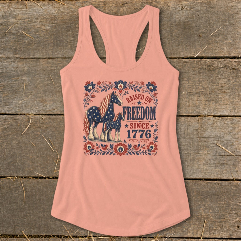 Peach tank top with a floral frame, two horses, and the text "Raised on Freedom Since 1776."