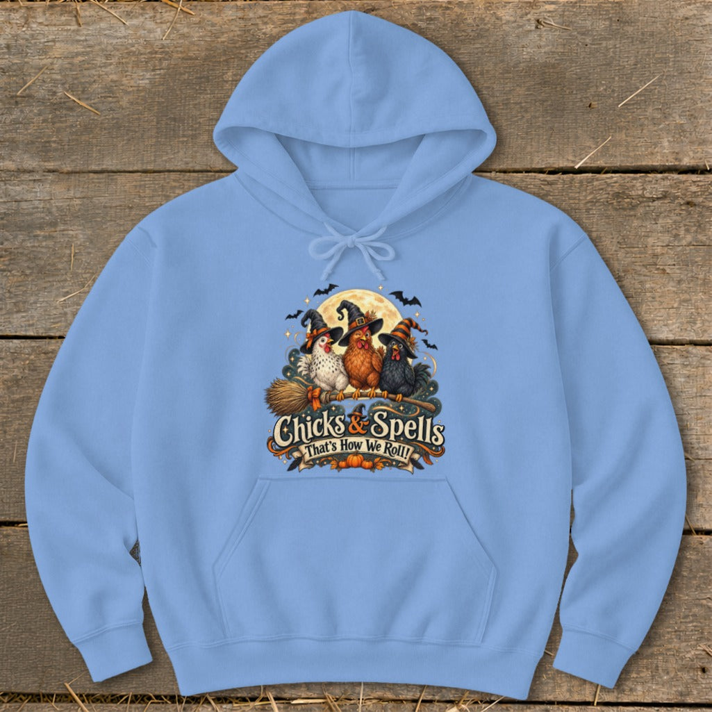 Light blue hoodie with a graphic of three witches' chickens on a broomstick with "Chicks & Spells" text.