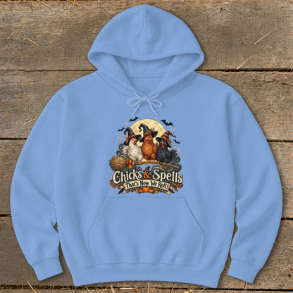 Light blue hoodie with a graphic of three witches' chickens on a broomstick with "Chicks & Spells" text.