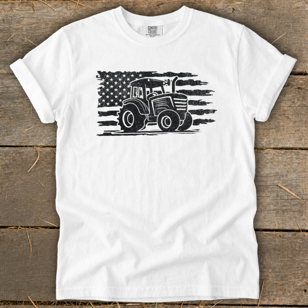 White t-shirt with distressed tractor silhouette on American flag graphic.