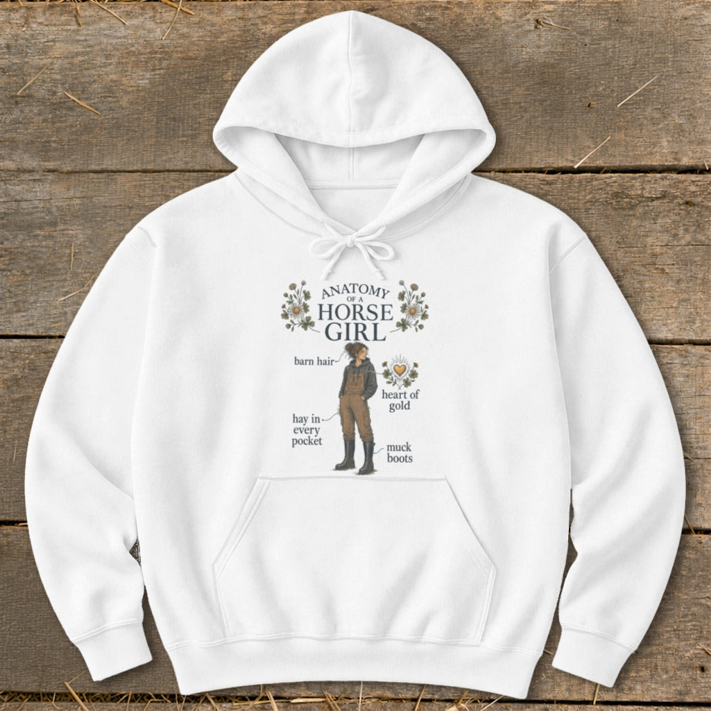 White hoodie with "Anatomy of a Horse Girl" graphic featuring a girl with barn hair, muck boots, and a heart of gold.
