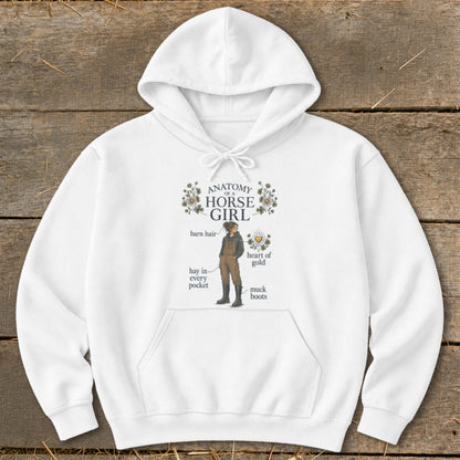 White hoodie with "Anatomy of a Horse Girl" graphic featuring a girl with barn hair, muck boots, and a heart of gold.