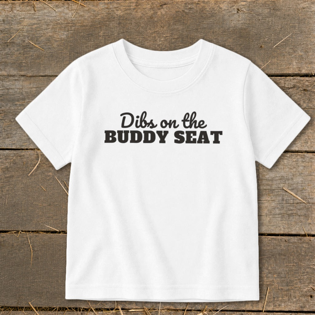 White t-shirt with black text "Dibs on the BUDDY SEAT"