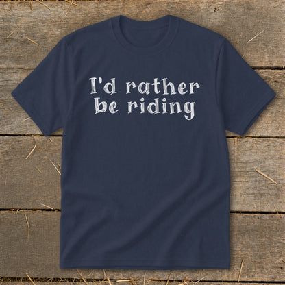 Navy t-shirt with white text "I'd rather be riding" on a wooden background.