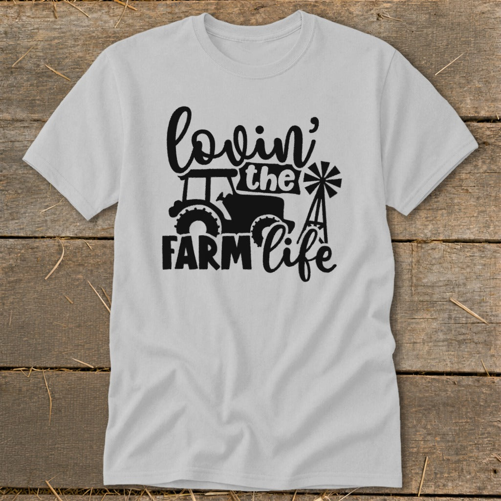 White t-shirt with black graphic of tractor, windmill, and text "lovin' the FARM life".