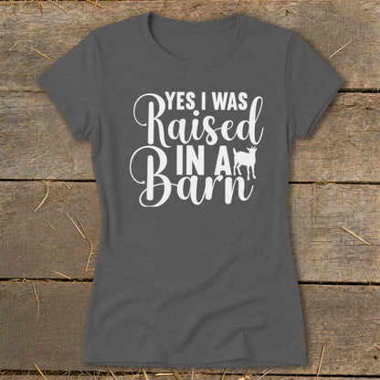 Dark gray t-shirt with white text "YES I WAS Raised IN A Barn" and a goat silhouette.