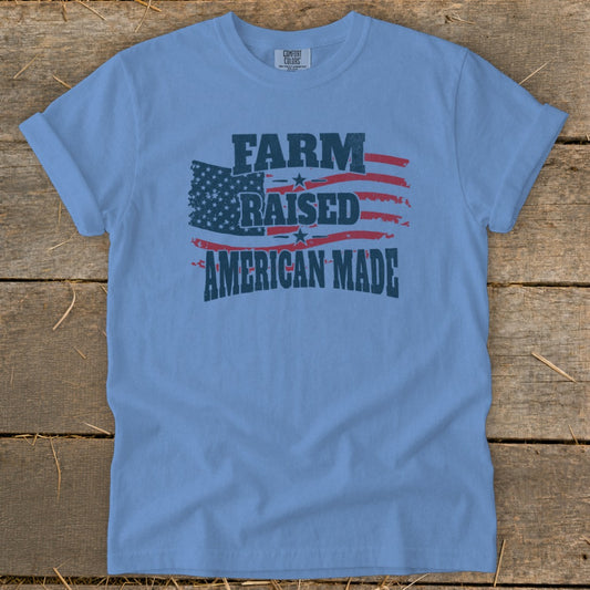 Light blue t-shirt with distressed American flag graphic and text "FARM RAISED AMERICAN MADE".