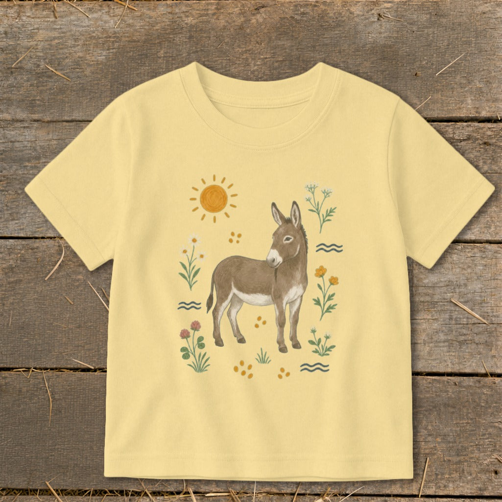 Yellow t-shirt with a brown donkey, sun, and floral illustrations.