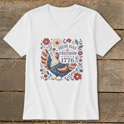 White v-neck t-shirt with patriotic chicken and "Fresh Eggs & Freedom Since 1776" text.