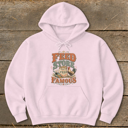 Pink hoodie with "Feed Store Famous" text, sack of feed, and rooster graphic.