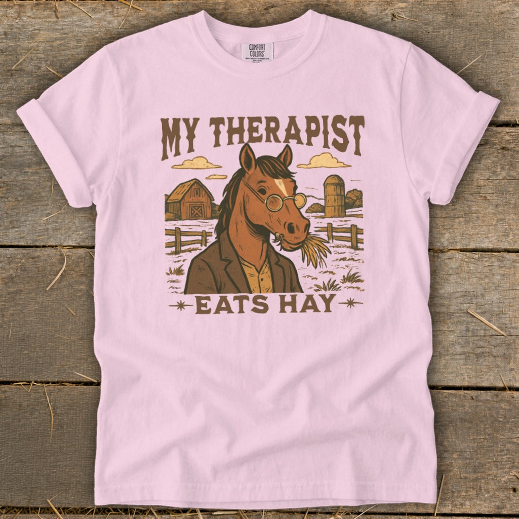 Pink t-shirt with horse in jacket and glasses eating hay, text "MY THERAPIST EATS HAY".