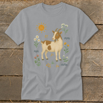 Light grey t-shirt with a watercolor-style illustration of a brown and white goat surrounded by flowers and a sun.