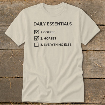 Light beige t-shirt with "Daily Essentials" checklist: 1. Coffee, 2. Horses, 3. Everything Else.