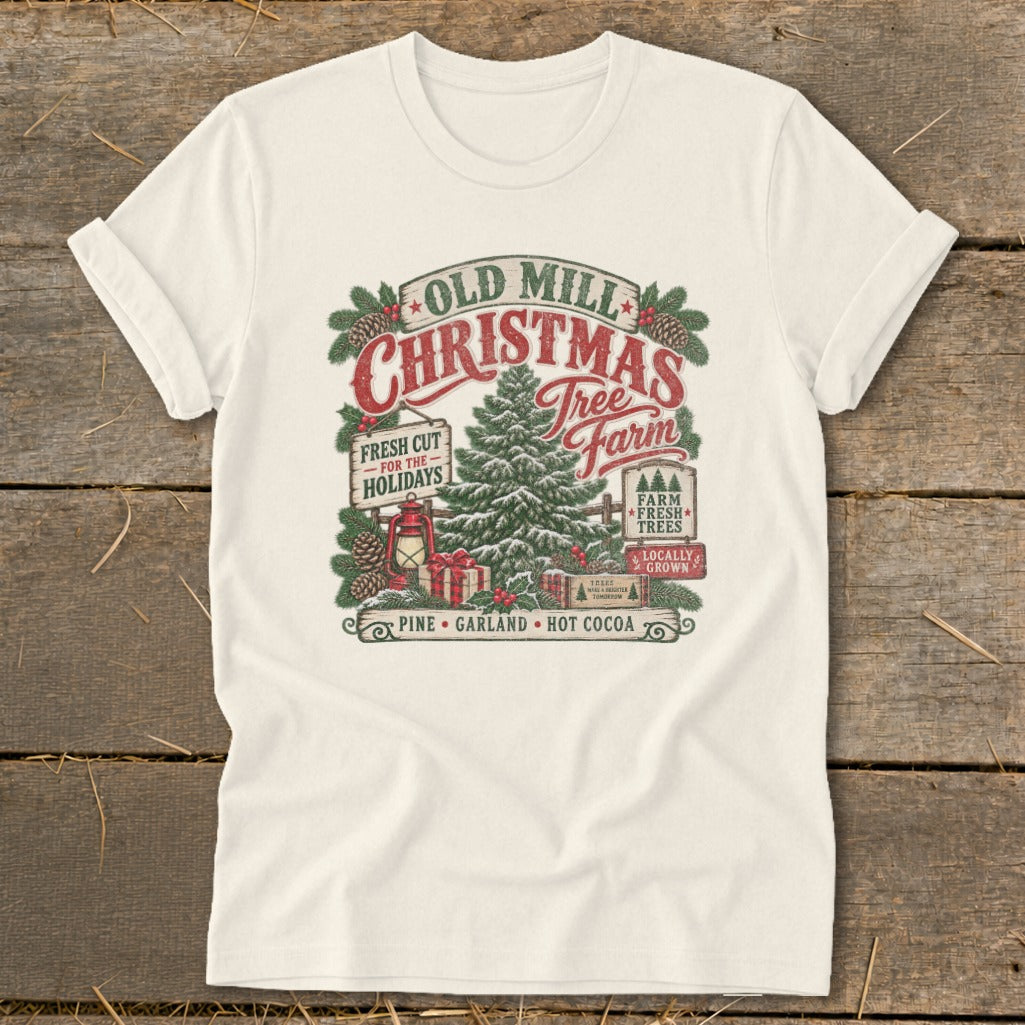 Cream t-shirt with Old Mill Christmas Tree Farm graphic featuring pine tree, gifts, and text.
