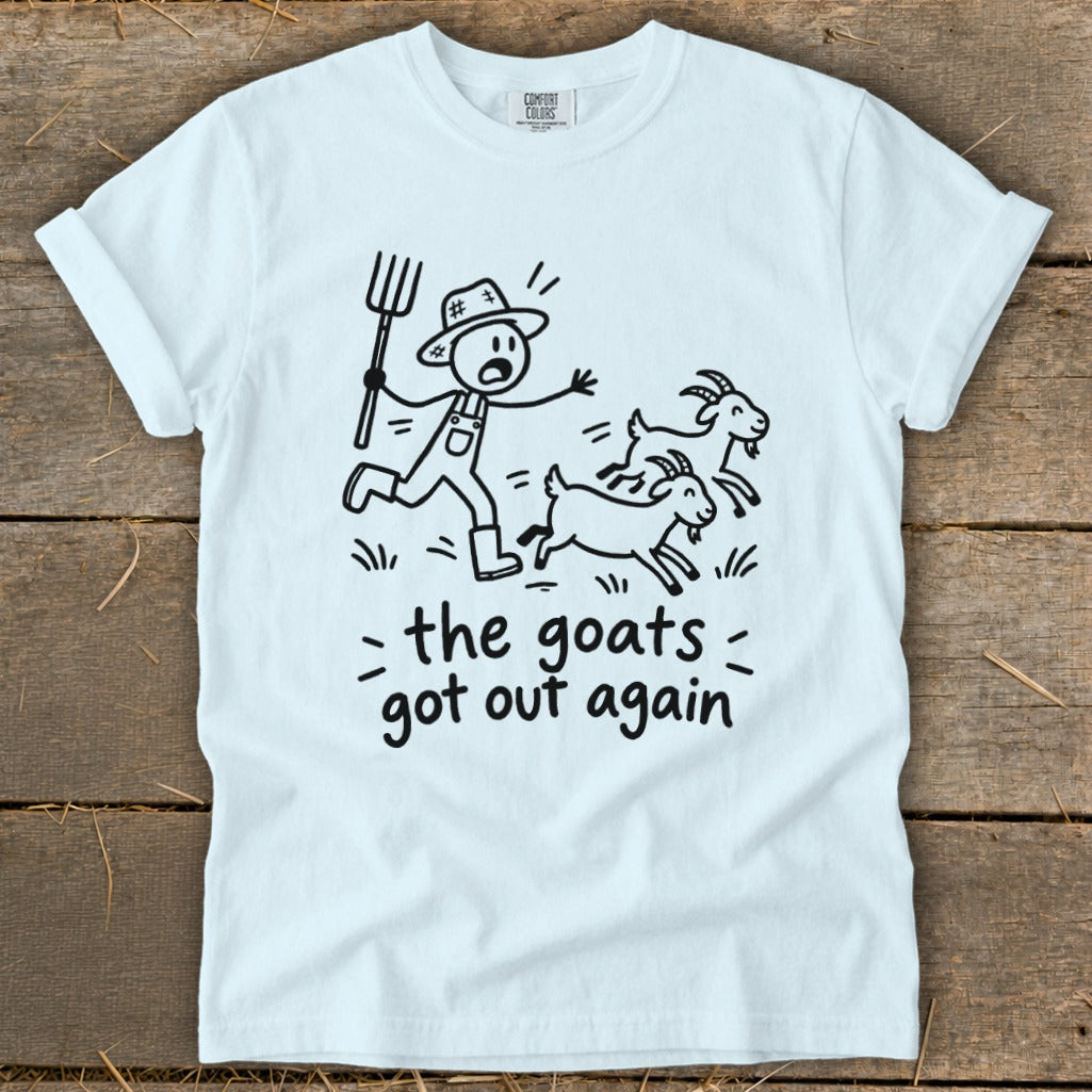 White t-shirt with a cartoon of a farmer chasing goats, text reads "the goats got out again".