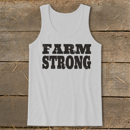 Light gray men's tank top with the distressed black text "FARM STRONG" on a rustic wooden background.