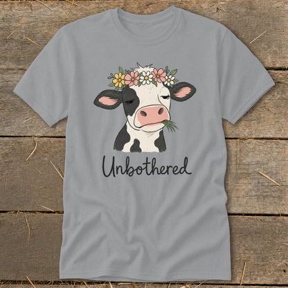 Gray t-shirt with a cow wearing a flower crown and chewing grass, text says "Unbothered".