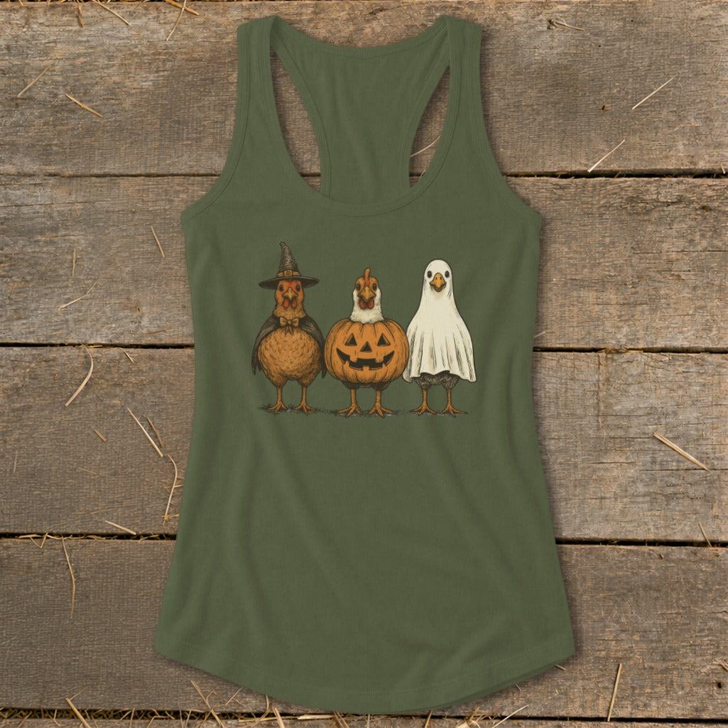 Three chickens dressed as a witch, pumpkin, and ghost on a green tank top.