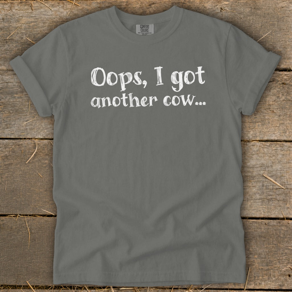 Gray t-shirt with white text reading "Oops, I got another cow...".