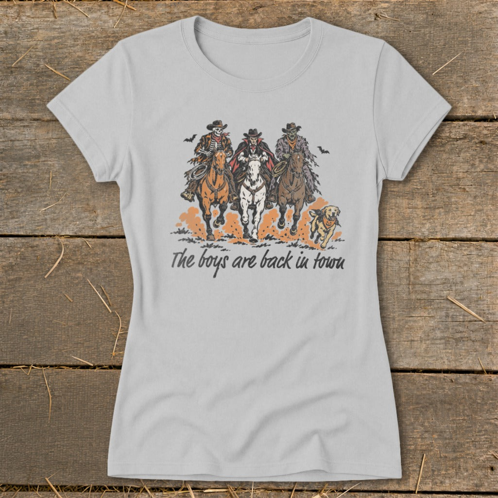 Skeleton, vampire, and zombie cowboys ride horses with a dog, text reads "The boys are back in town."