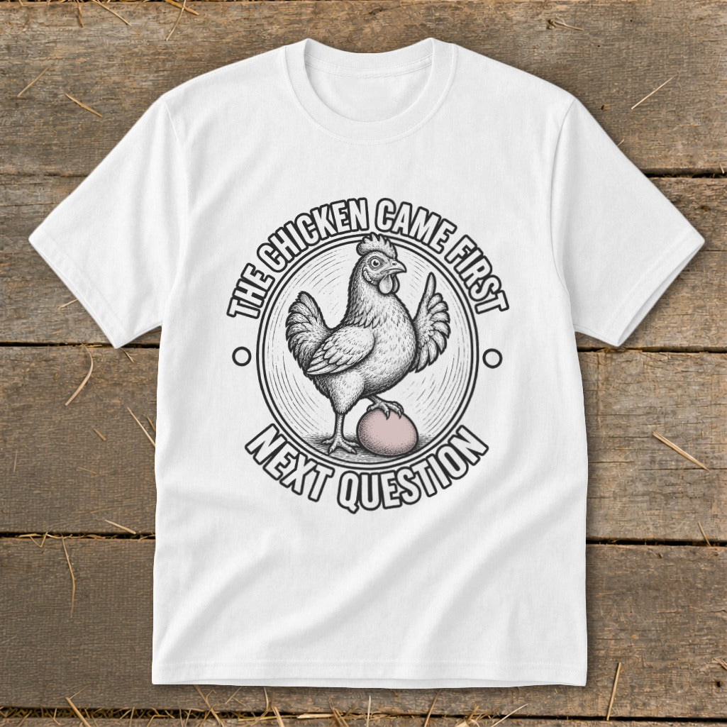 White t-shirt with a chicken on an egg and text: The chicken came first, next question.