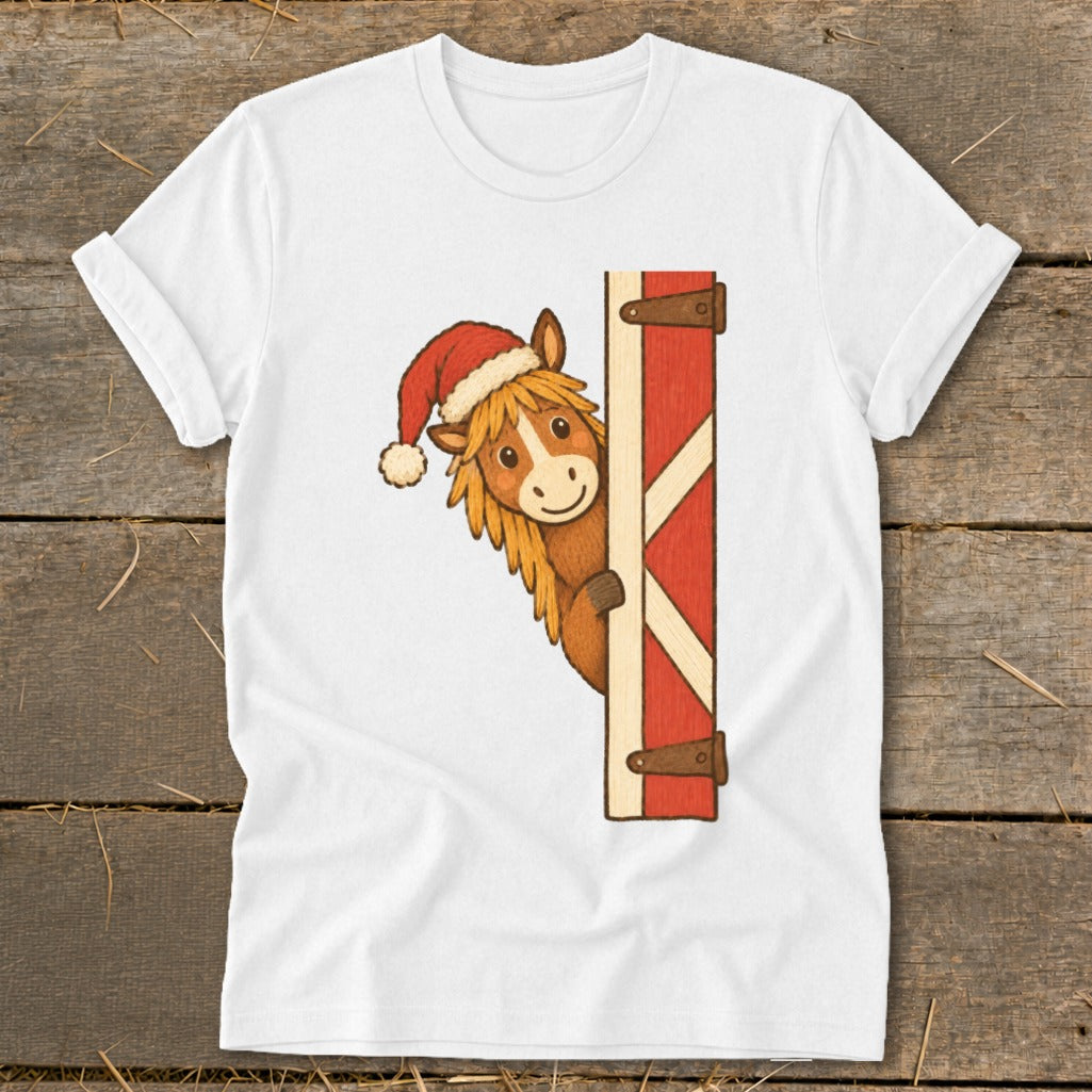 White t-shirt with a cartoon horse wearing a Santa hat peeking from behind a red barn door.