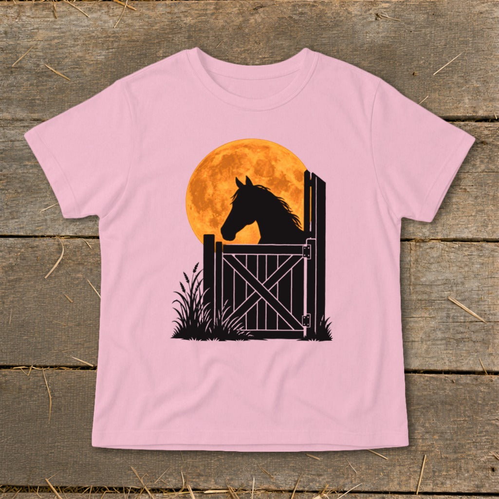 A pink t-shirt featuring a graphic of a horse silhouette looking over a gate against an orange moon.