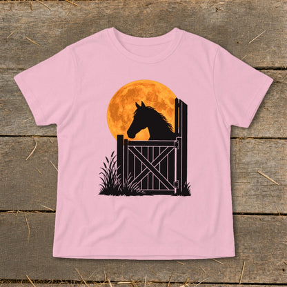 A pink t-shirt featuring a graphic of a horse silhouette looking over a gate against an orange moon.