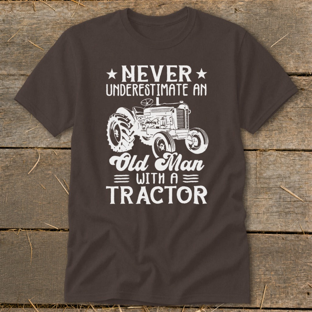 Brown t-shirt with white text and tractor graphic: Never Underestimate An Old Man With A Tractor.