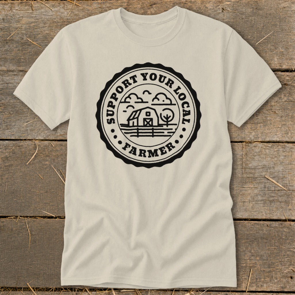 Cream t-shirt with black circular graphic reading "SUPPORT YOUR LOCAL FARMER" and depicting a barn and tree.
