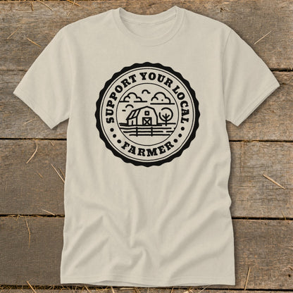 Cream t-shirt with black circular graphic reading "SUPPORT YOUR LOCAL FARMER" and depicting a barn and tree.