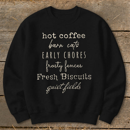 Black sweatshirt with text: hot coffee, barn cats, EARLY CHORES, frosty fences, Fresh Biscuits, quiet fields.