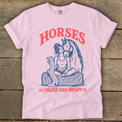 Pink t-shirt with "HORSES CHEAPER THAN THERAPY" graphic featuring a woman and a horse.