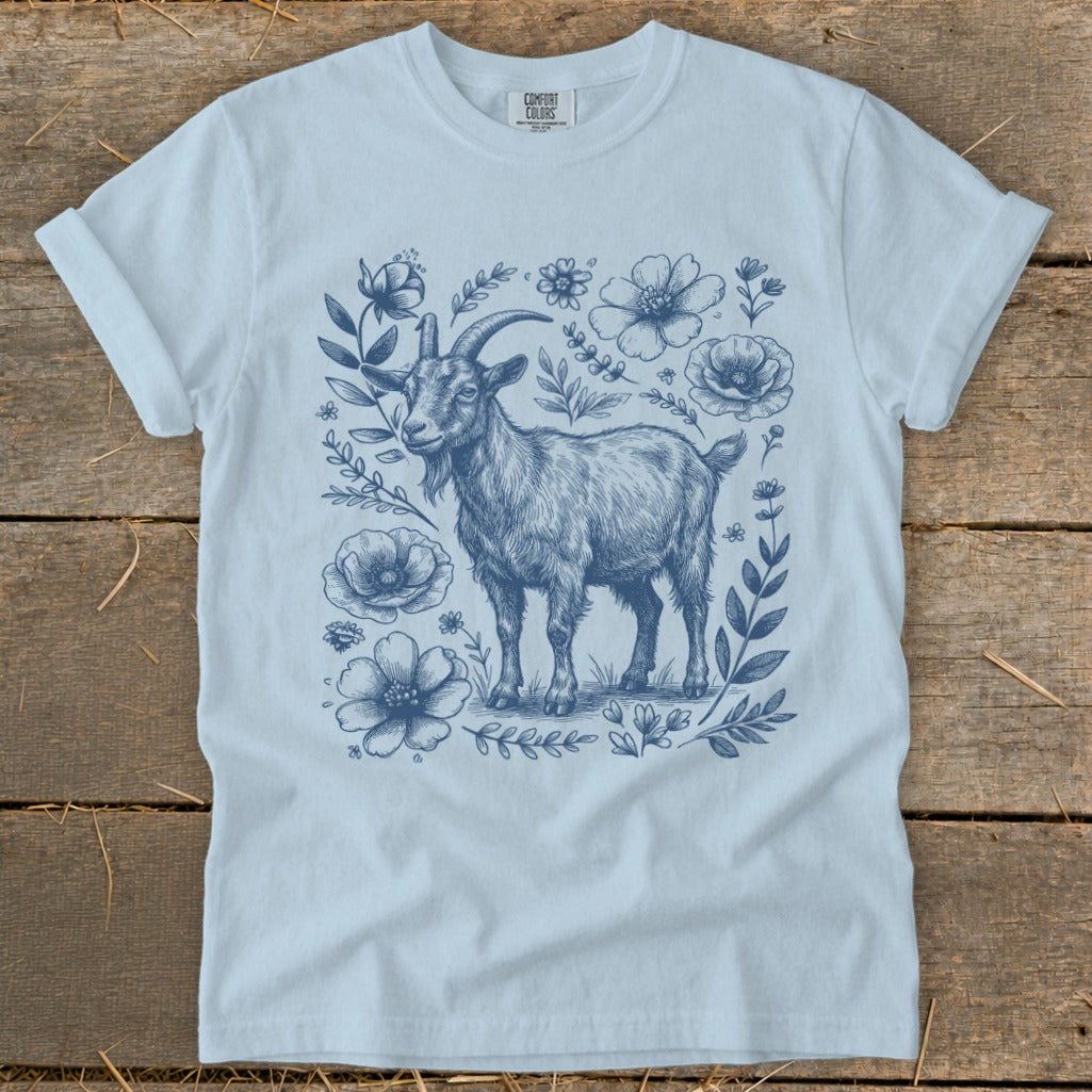 Light blue t-shirt with a detailed blue sketch of a goat surrounded by flowers.