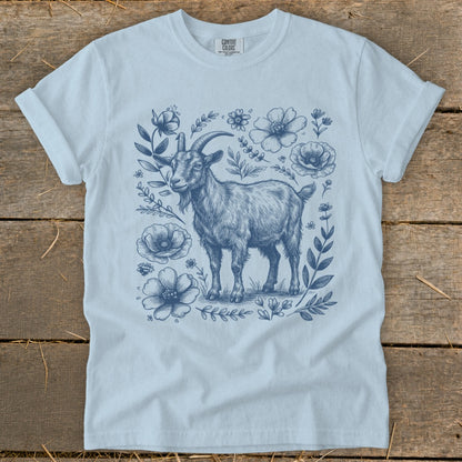 Light blue t-shirt with a detailed blue sketch of a goat surrounded by flowers.