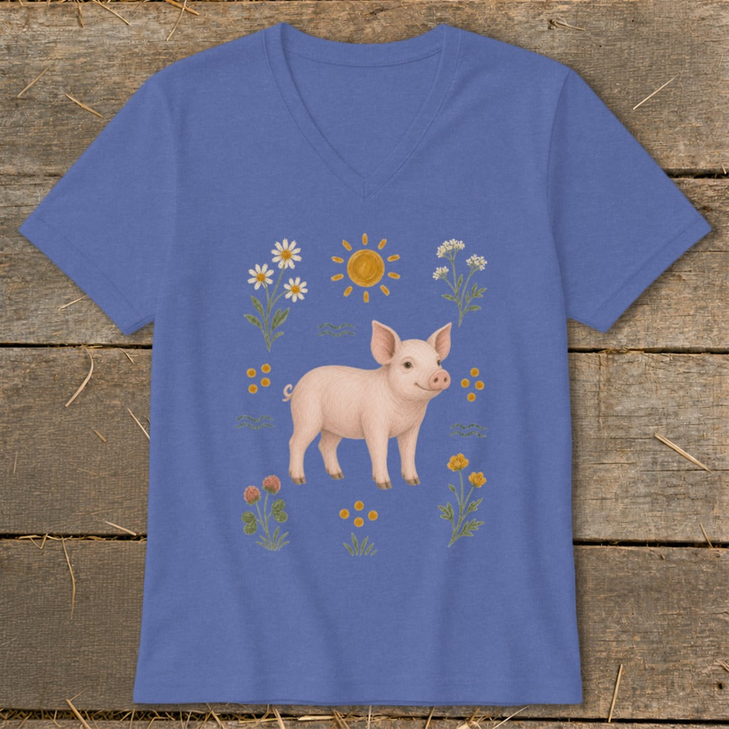 Piglet surrounded by flowers, clover, and a smiling sun illustration on a blue v-neck t-shirt.