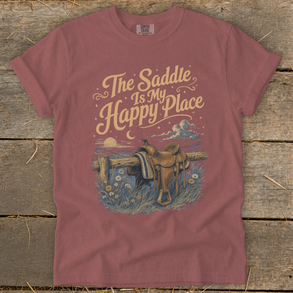 T-shirt graphic: "The Saddle Is My Happy Place" with western saddle on fence.