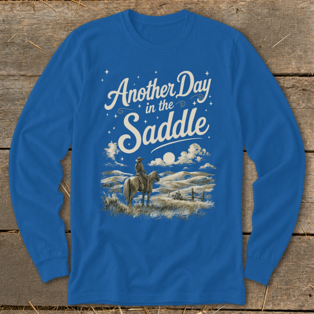 Blue long-sleeve shirt with "Another Day in the Saddle" text and cowboy on horse graphic.