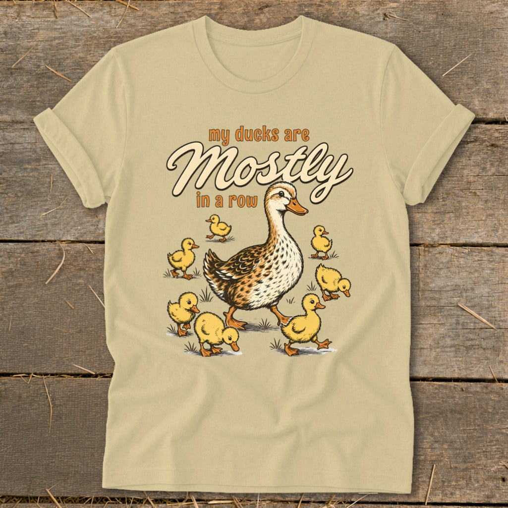 T-shirt graphic with a duck leading ducklings and text "my ducks are Mostly in a row".