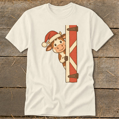 Cream t-shirt with a cartoon cow wearing a Santa hat peeking around a barn door.