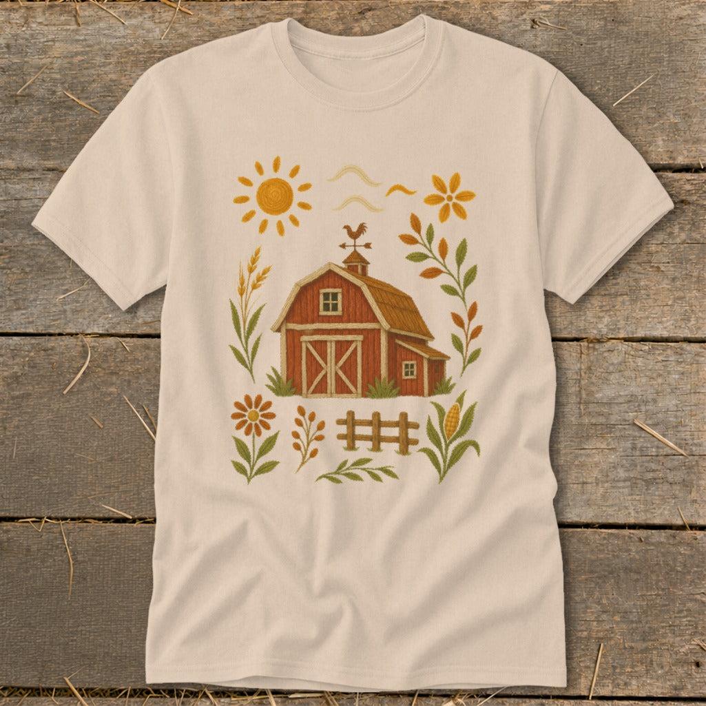 T-shirt with a whimsical farm scene including a barn, sun, and floral accents.