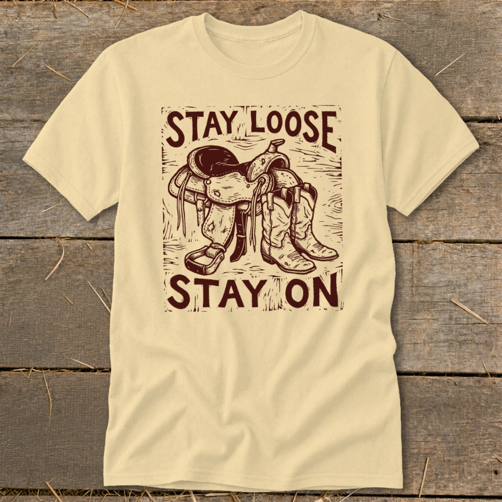 Light yellow t-shirt with "STAY LOOSE STAY ON" and saddle and boots graphic.